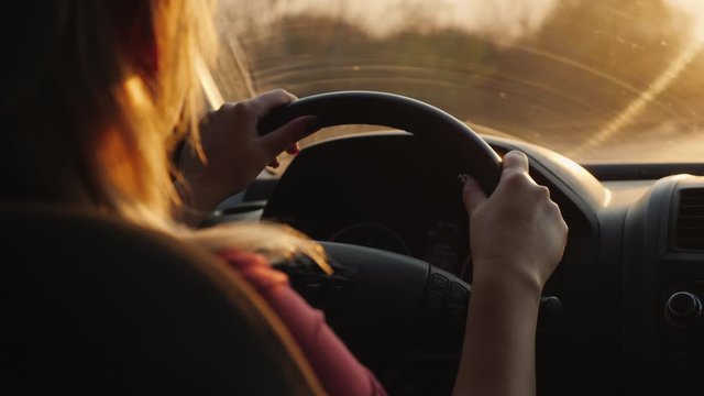 Back view of a female driver driving a car