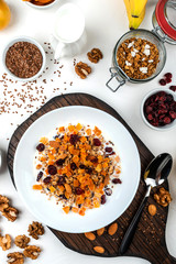 Healthy breakfast. Granola muesli with milk, dried apricots, cranberries, almonds and flax seeds. Clean eating, diet, detox, vegetarian food.