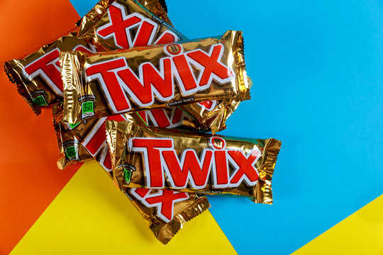 A close-up of Twix cookie bars candy bars on orange blue and yellow background.