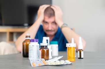 bottles of medication and a worried man