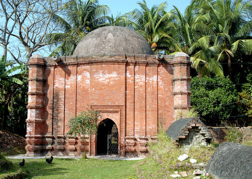 Zinda Pir Mosque in Bagerhat, Bangladesh. Brick construction and dome of the Zinda Pir Mosque with old tombs in the foreground. Bagerhat UNESCO world heritage site, Bangladesh.