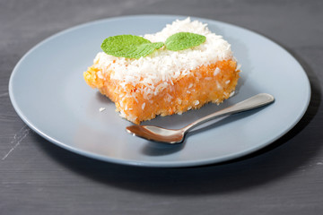 Slice of fresh homemade pumpkin pie and semolina on a grey plate on a dark background. . A Thanksgiving or holiday treat. Traditional autumn dish