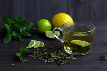 green tea with lemon and fresh mint on wooden background. healthy lifestyle.