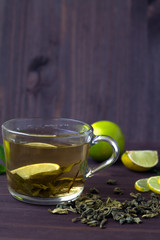 cup of green tea with fresh lime on dark wooden table