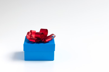 Blue gift box with red bow on white background
