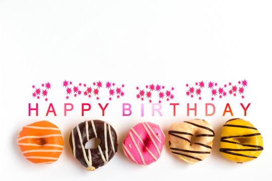 Colorful donuts on white background, With happy birthday text.