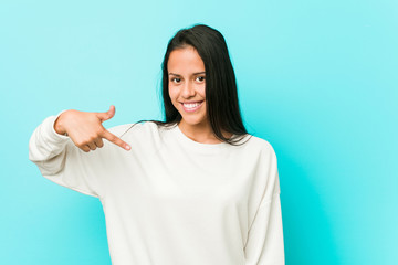 Young pretty hispanic woman person pointing by hand to a shirt copy space, proud and confident