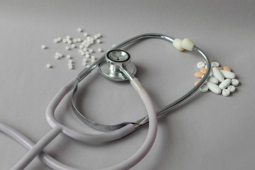 stethoscope between conventional medicines white and orange pills and natural medicines,...