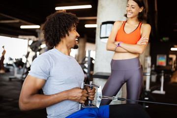 Fototapeta premium Happy fit friends exercising, working out in gym to stay healthy together