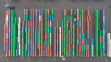 TOP DOWN: Industrial forklift drives past rows of multicolored containers.