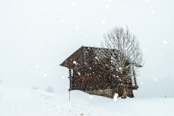 wooden cabin in the austrian alps, covered with snow