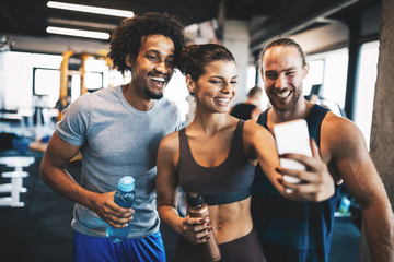 Group of friends having fun at the gym, making a selfie