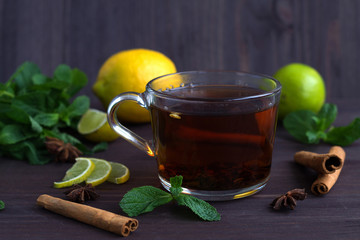 cup of tea with lemon and spices on wooden table