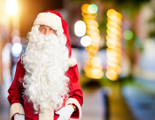 Middle age handsome man wearing Santa Claus costume and beard standing making fish face with lips, crazy and comical gesture. Funny expression.