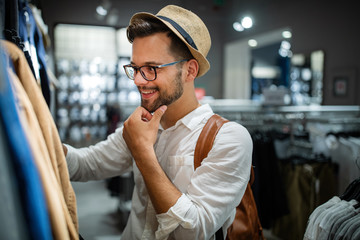 Portrait of a handsome man shopping for clothes at shop
