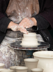 Old woman working on a pottery wheel
