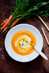 Creamy Carrot Soup on brown wooden background