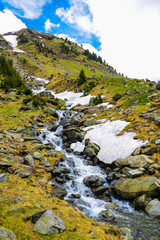 Mountain stream flows on a mountain slope, selective focus.