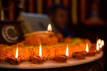Happy Diwali - Clay Diya lamps lit during Dipavali, Hindu festival of lights celebration. Colorful traditional oil lamp diya and sweets on marble background
