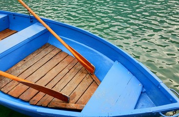 Fototapeta na wymiar blue wooden boat with oars on the lake