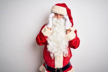 Middle age handsome man wearing Santa costume standing over isolated white background with hand on headache because stress. Suffering migraine.