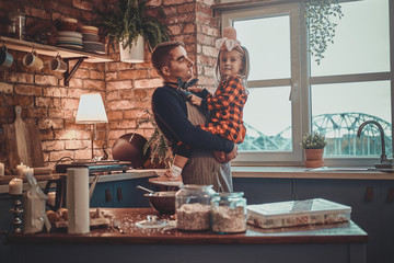 Father with dracula makeup and his little daughter in hat are ready for Halloween party.