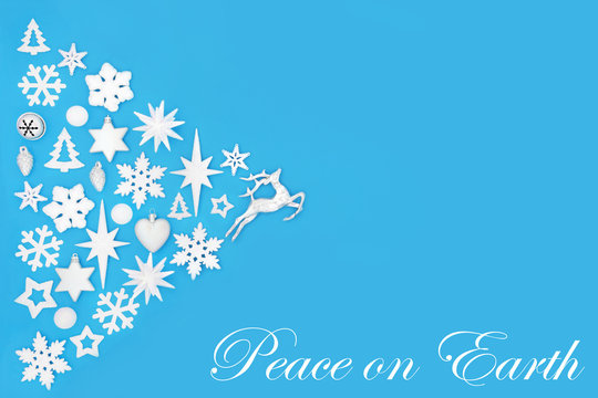 Christmas peace on earth abstract background with white and silver tree decorations and symbols on blue with copy space. Traditional theme for the festive season.