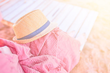 Straw hat on a hot day off on womans leg with plaid