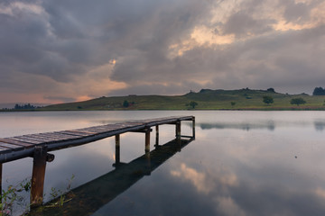 Obraz premium Landscape of a jetty on a dam with dramatic clouds of rain storm
