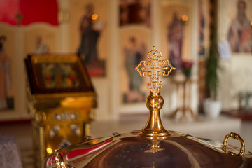 Fototapeta na wymiar gold Church cross on a blurred background of icons