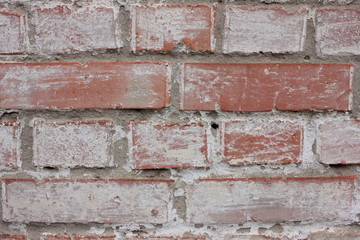 The texture of the old brick wall painted white with peeling paint. White grunge brick wall background