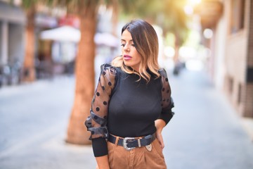 Fototapeta premium Young beautiful woman smiling happy and confident. Standing and walking at town street