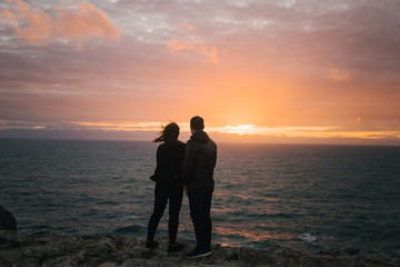  Couple near a cliff at sunset