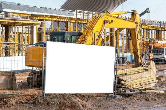 yellow excavator working on dirty construction site steel fence white mock-up