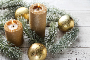 Christmas candles with baubles and fir tree branches on white wooden table