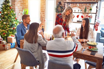 Beautiful family meeting smiling happy and confident. Carving roasted turkey celebrating Christmas at home