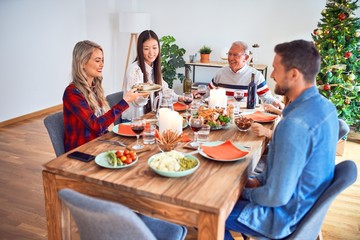 Beautiful family meeting smiling happy and confident. Eating roasted turkey celebrating Christmas at home