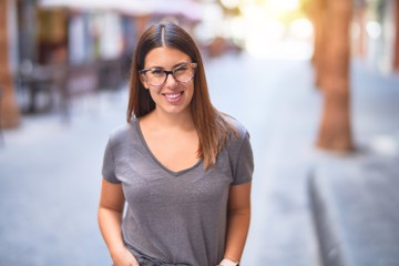 Young beautiful woman smiling happy and confident. Standing with smile on face at town street