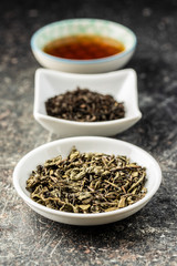 Dried black and green tea leaves.