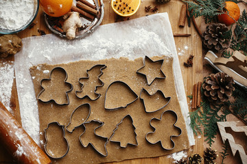 Gingerbread dough with metal cutters in different shapes for christmas cookies and wooden rolling...