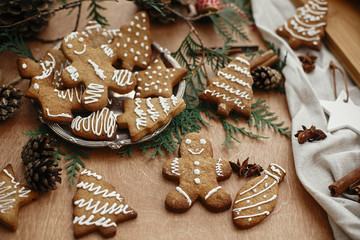 Christmas gingerbread man,  cookies on vintage plate and anise, cinnamon, pine cones and cedar branches on rustic table. Baked traditional gingerbread cookies. Seasons greetings © sonyachny