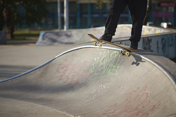 Man in skatepark rides skateboard on warm autumn day