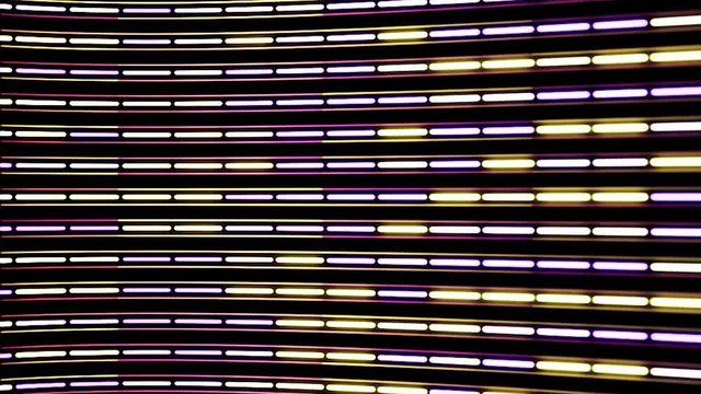 Horizontal flow of abstract neon lines of purple and yellow colors with camera lens distort on black background. Animation. Narrow stripes devided into segments, seamless loop.