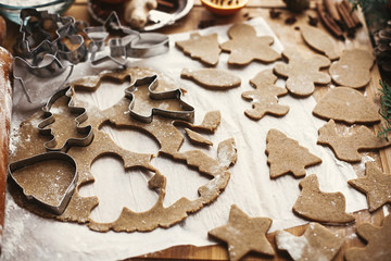 Gingerbread dough with metal cutters in different shapes for christmas cookies and wooden rolling...