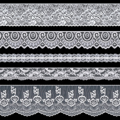 Set of elegant white lace ribbons on a black background. Lace braid.