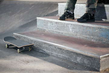 View of black skateboard in concrete skatepark on warm day