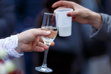 the clink of a champagne glass and a plastic Cup