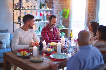 Beautiful family smiling happy and confident. Eating roasted turkey celebrating Christmas at home