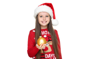 Little girl in christmas sweater and hat holding bauble on white background