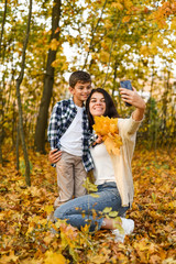 Fototapeta premium mom and son take selfies in the autumn forest. copy space